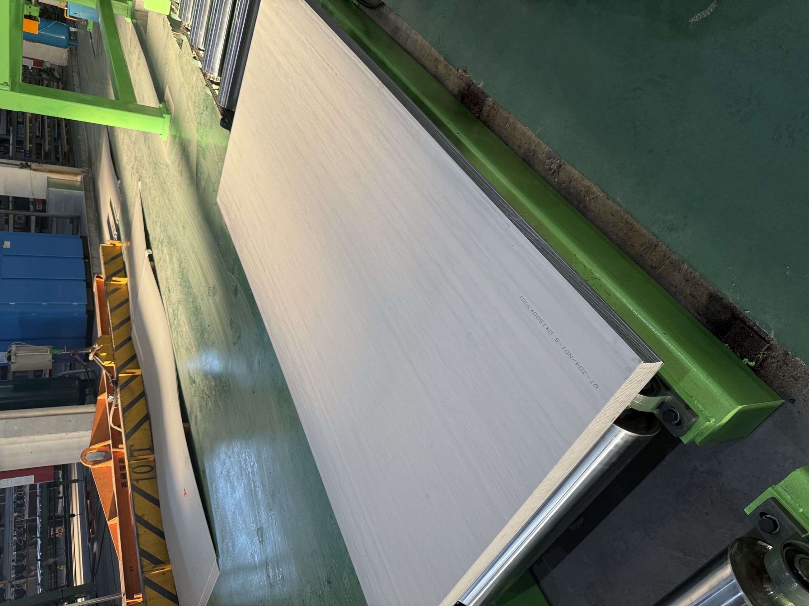 Provided factory material showing stainless-steel plate moving through a roller line
